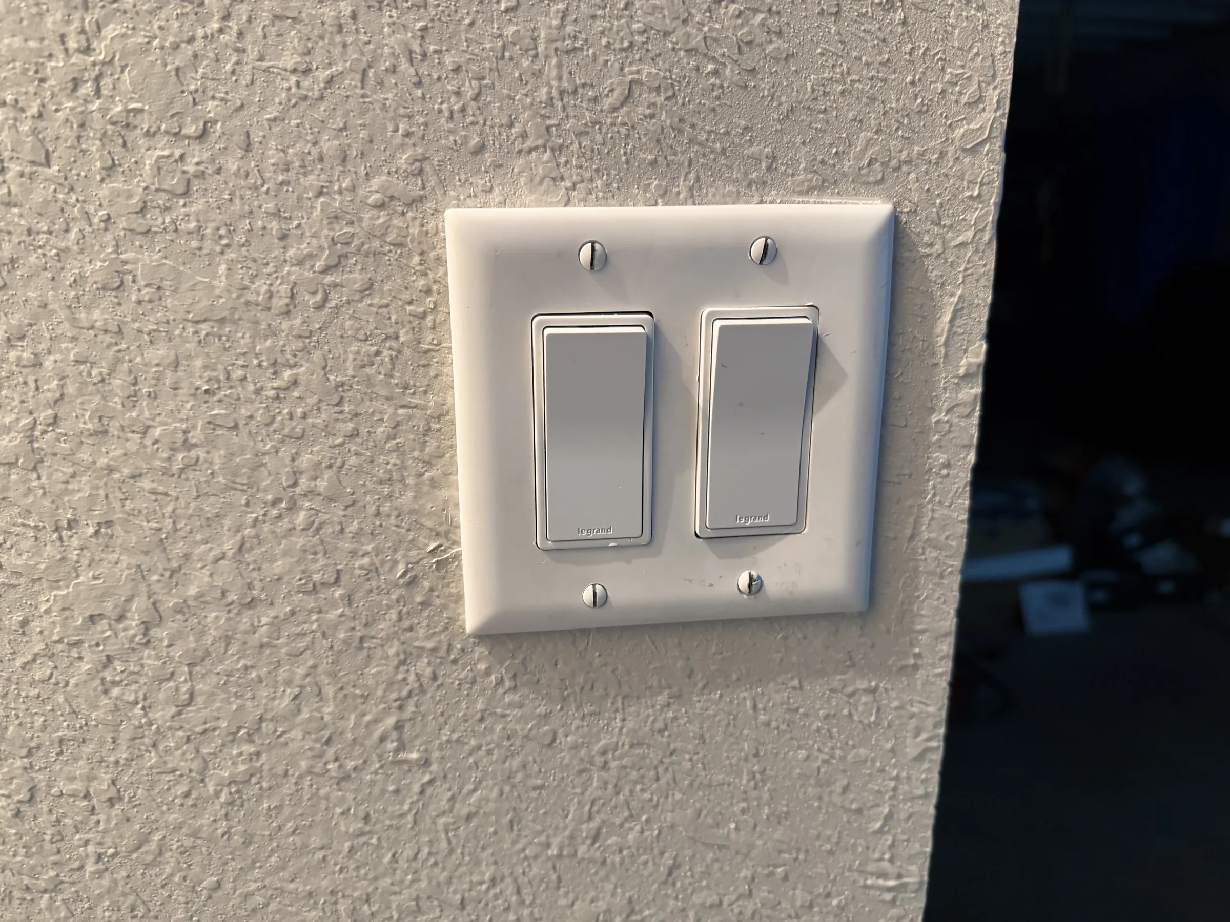 Outside of switch. Left switch goes to 3-way in stairwell, right switch goes to existing basement lights.